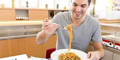 man eating pasta