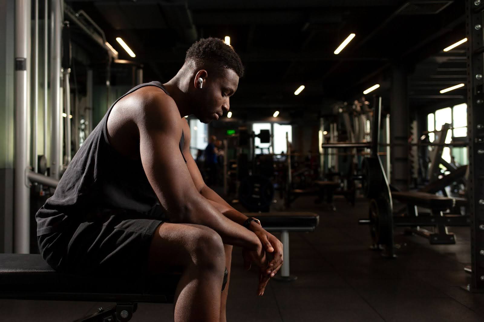 Fit man resting in a gym in between workouts